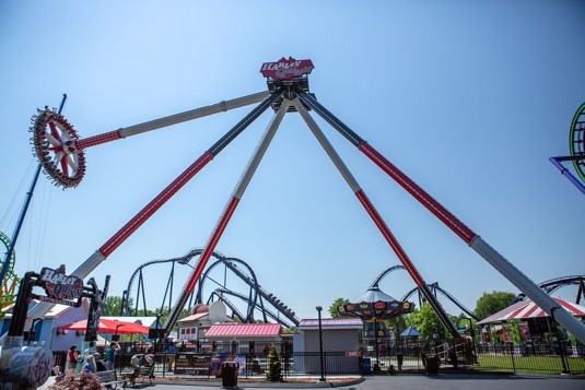 This ride, supported by four long legs, spins a circular car on a rotating arm.