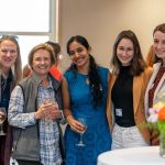 A group of women pose together, smiling, at the reception.