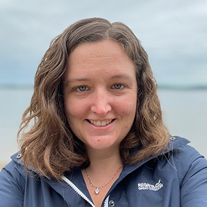 Close up of a woman with a large body of water in the background