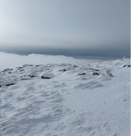 Snow-covered terrain under a grey sky.