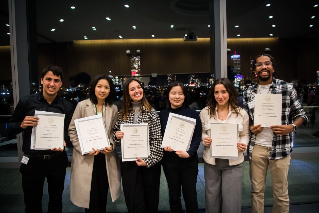 Presidential Fellows smile warmly as they hold their certificates.