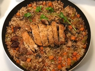 A rice, vegetable, and meat dish, plated in a bowl.