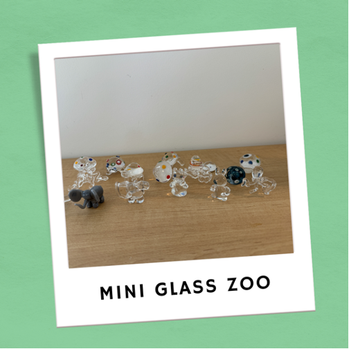 A photo of a small glass zoo in an illustration of a Polaroid frame.